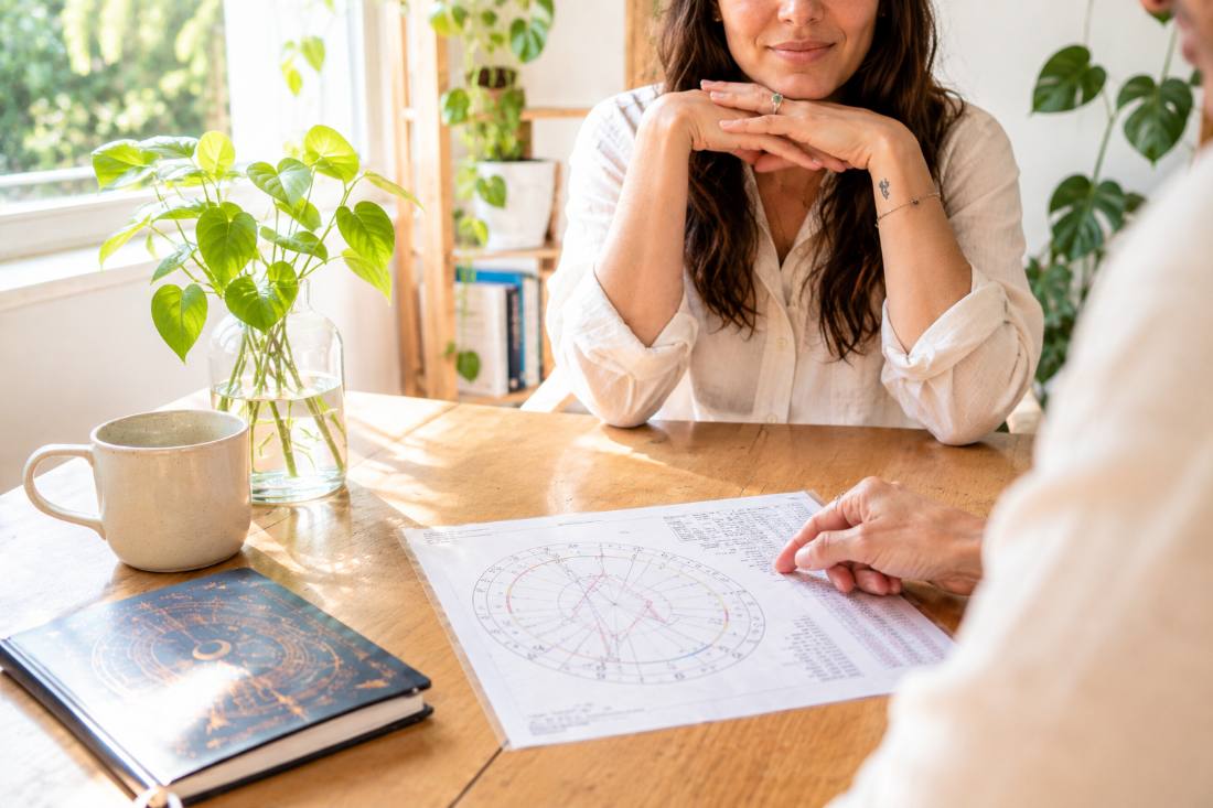 A natal chart reading with a client at the table