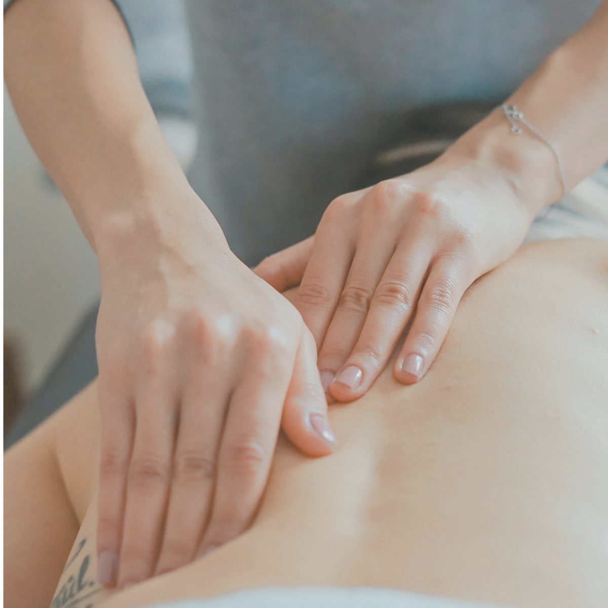 Hands working deep into a client's lower back